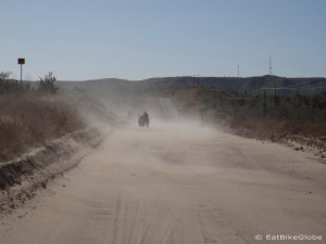 Jo pushing her bike through the sand near La Paz