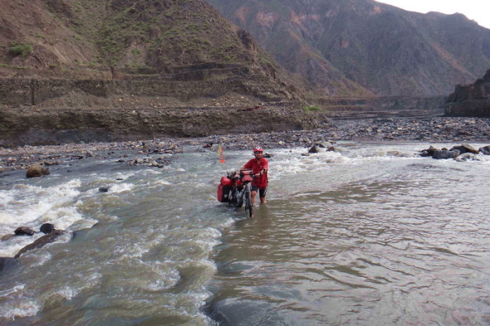 Peru  - David taking Jo's bike across the river - the current was strong and the water came up to our thighs at times! 